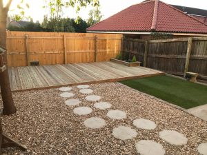 Large deck area with power supply led deck lighting, up and down LED lighting, stepping stones and a small yet complimentary lawn.