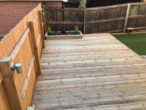 Large deck area with power supply led deck lighting, up and down LED lighting, stepping stones and a small yet complimentary lawn.
